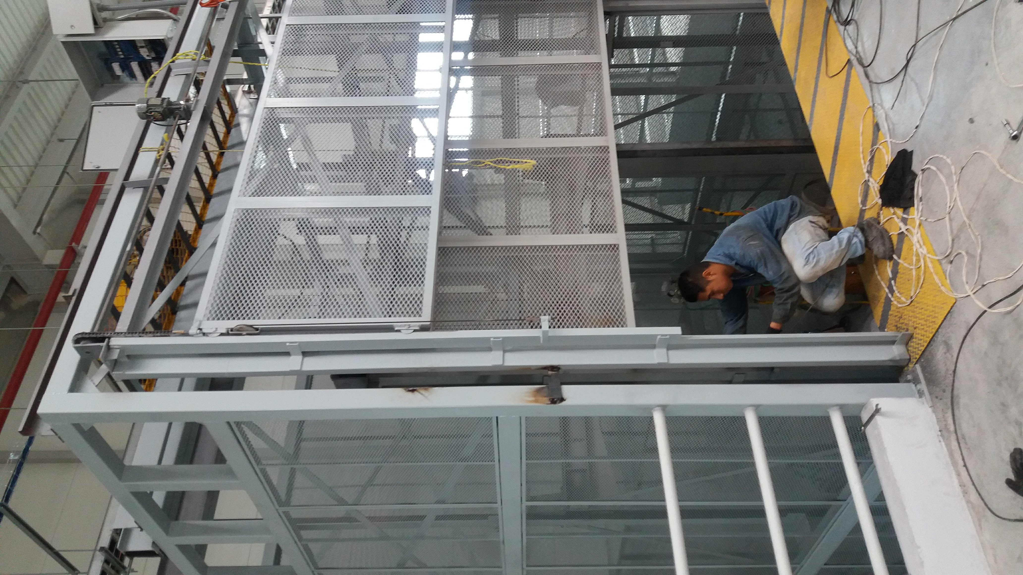 Montaje de elevador de carga EPCCSA con cerramiento de malla y barandal de protección en nave industrial