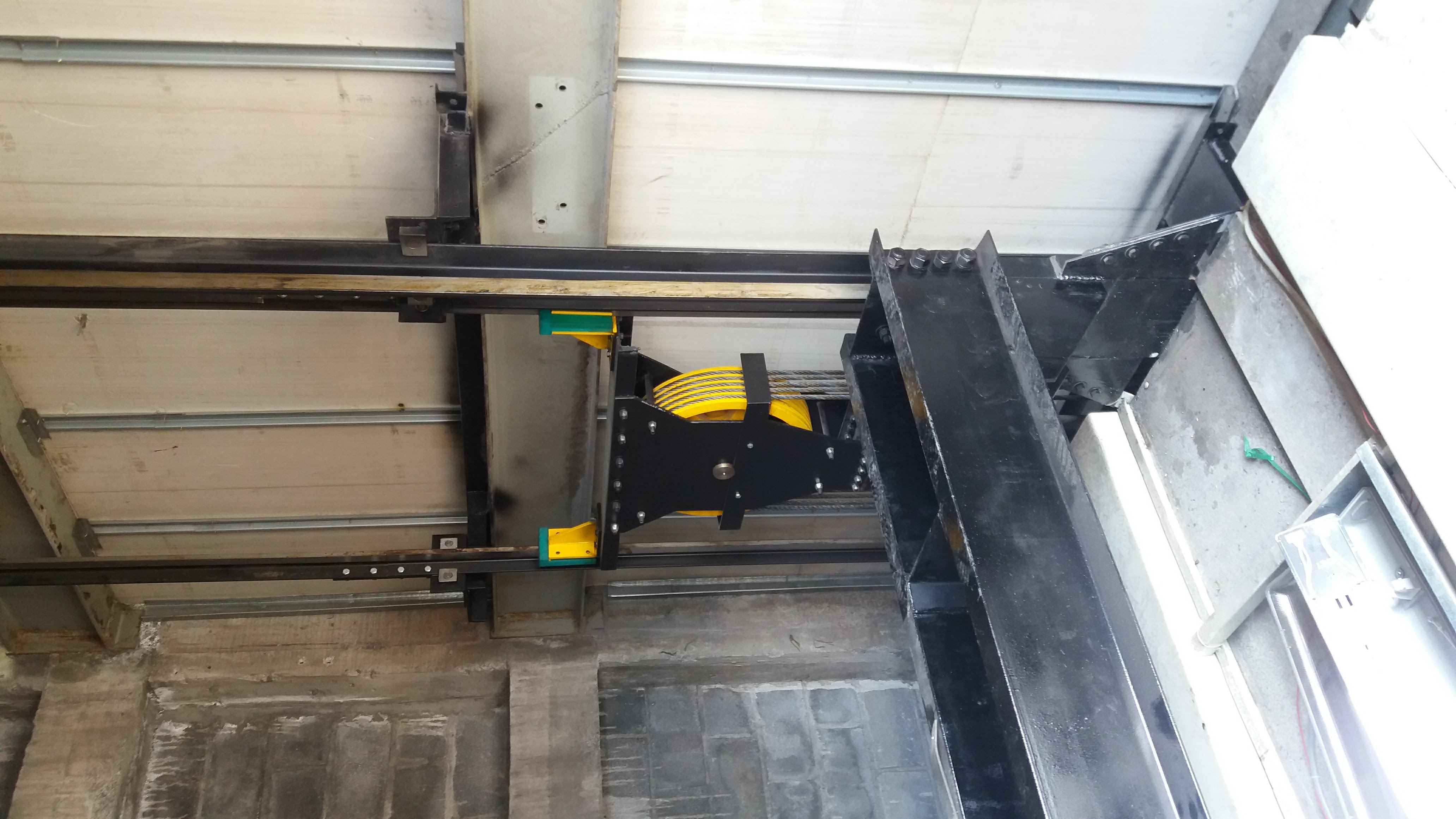 Detalle de polea, cables y rieles guía de elevador de carga EPCCSA dentro del cubo