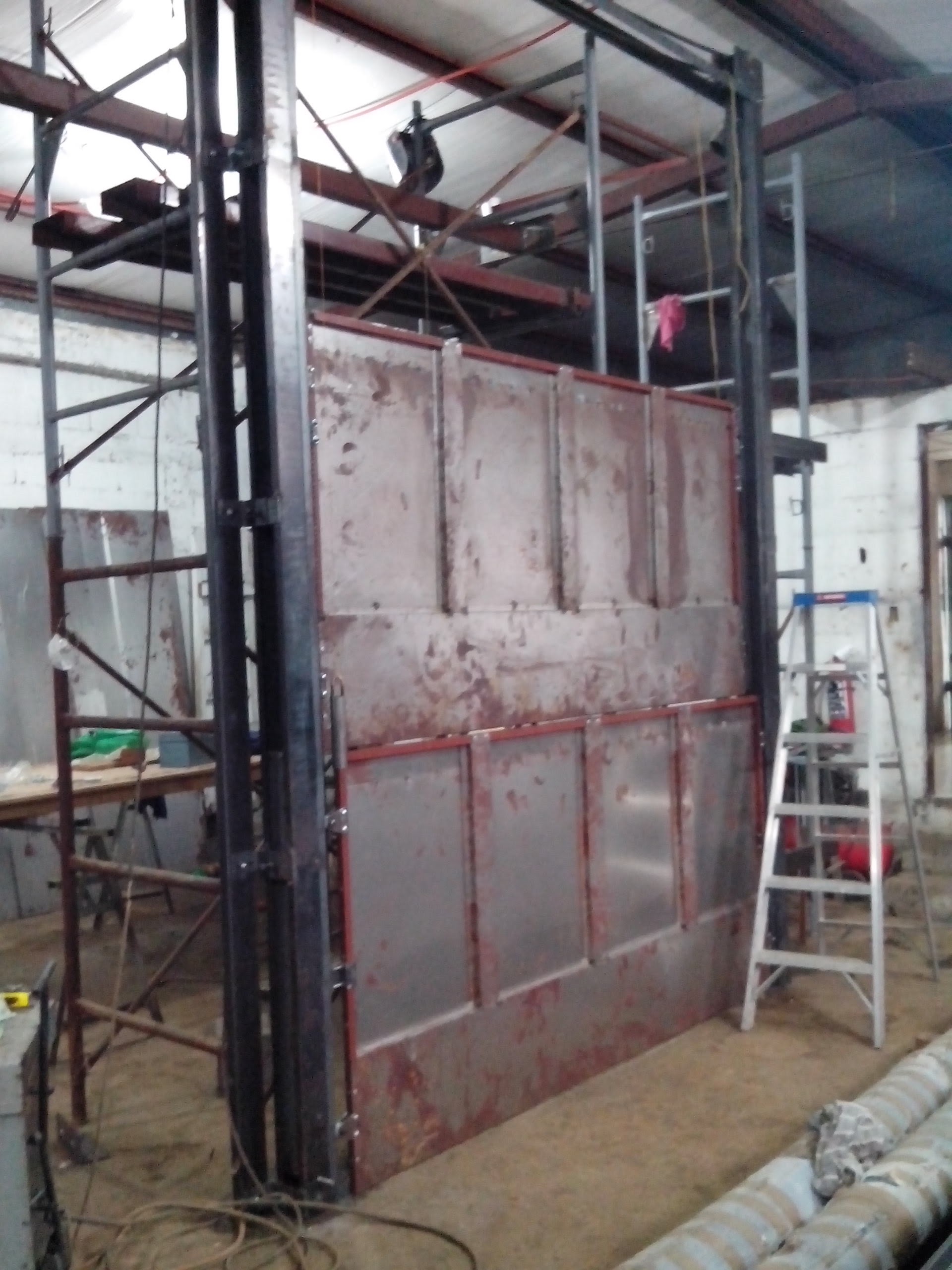 Cabina de elevador de carga EPCCSA montada sobre estructura con rieles guía en taller