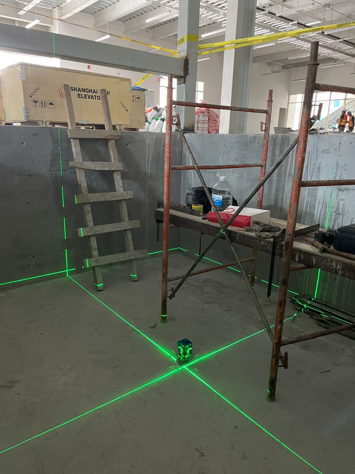 Trazo con nivel láser en foso de cubo para instalación de elevador de carga EPCCSA en obra