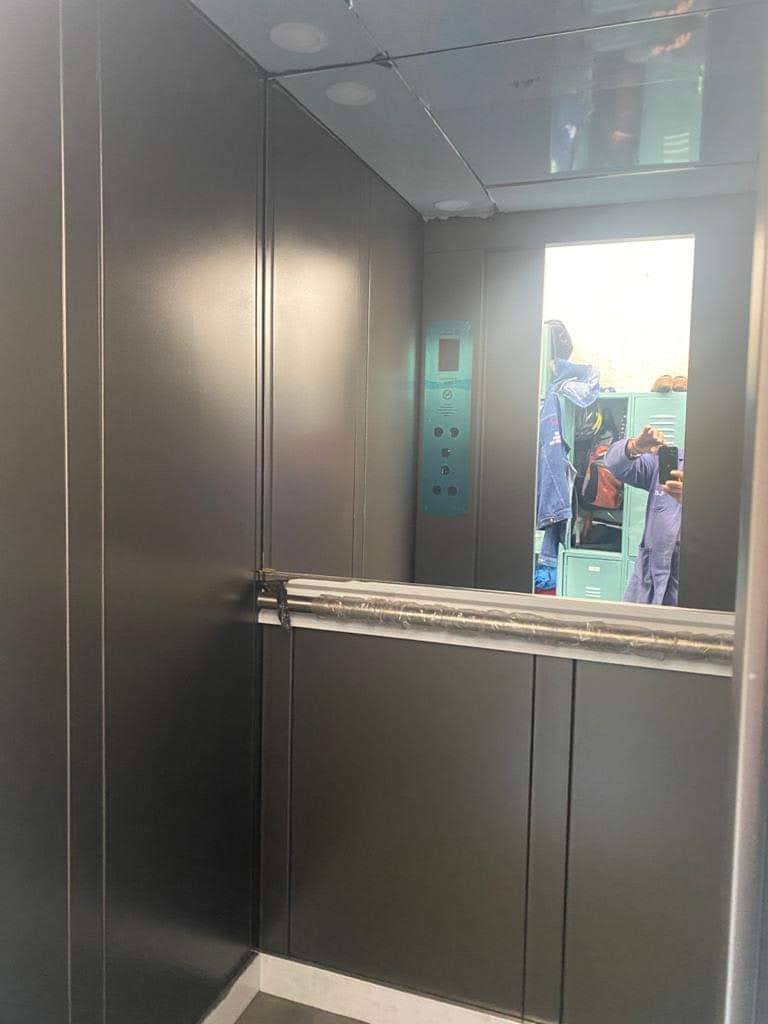 Interior de cabina de elevador residencial EPCCSA en acabado gris con espejo y botonera
