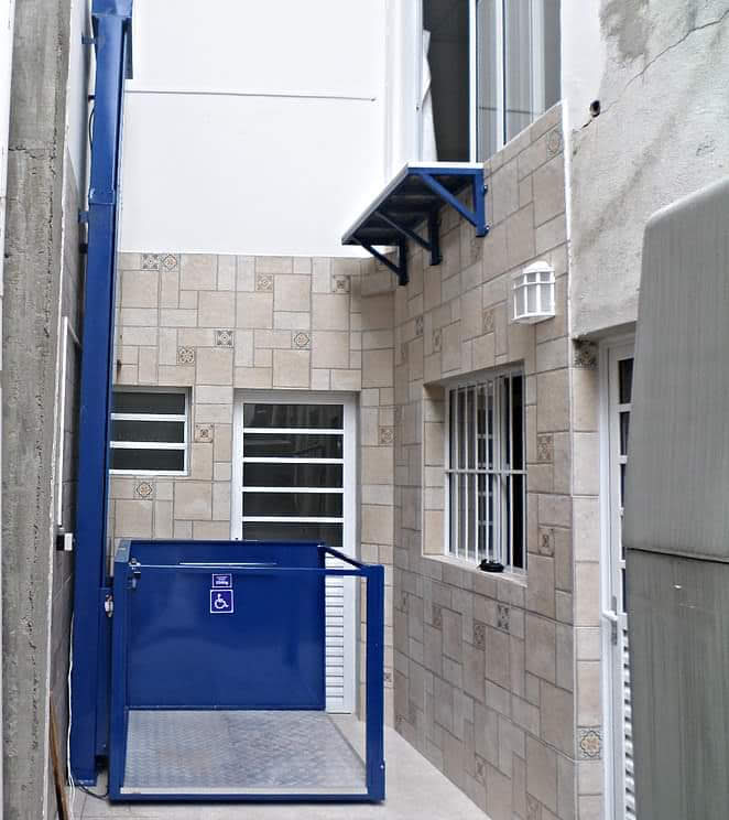 Plataforma elevadora EPCCSA azul para accesibilidad instalada en patio exterior